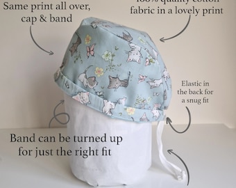 May include: A light blue cotton cap with a cat print. The cap has an elastic band in the back for a snug fit and a toggle and ties for easy size adjustment. The band can be turned up for a custom fit.