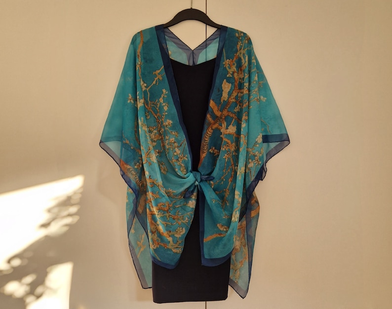 May include: A blue and gold patterned kimono-style wrap with a floral design. The wrap is tied at the waist and has a loose, flowing fit.