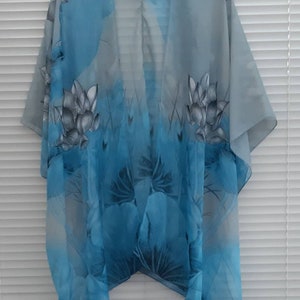 May include: A sheer blue and gray floral print kimono with a V-neck and short sleeves.