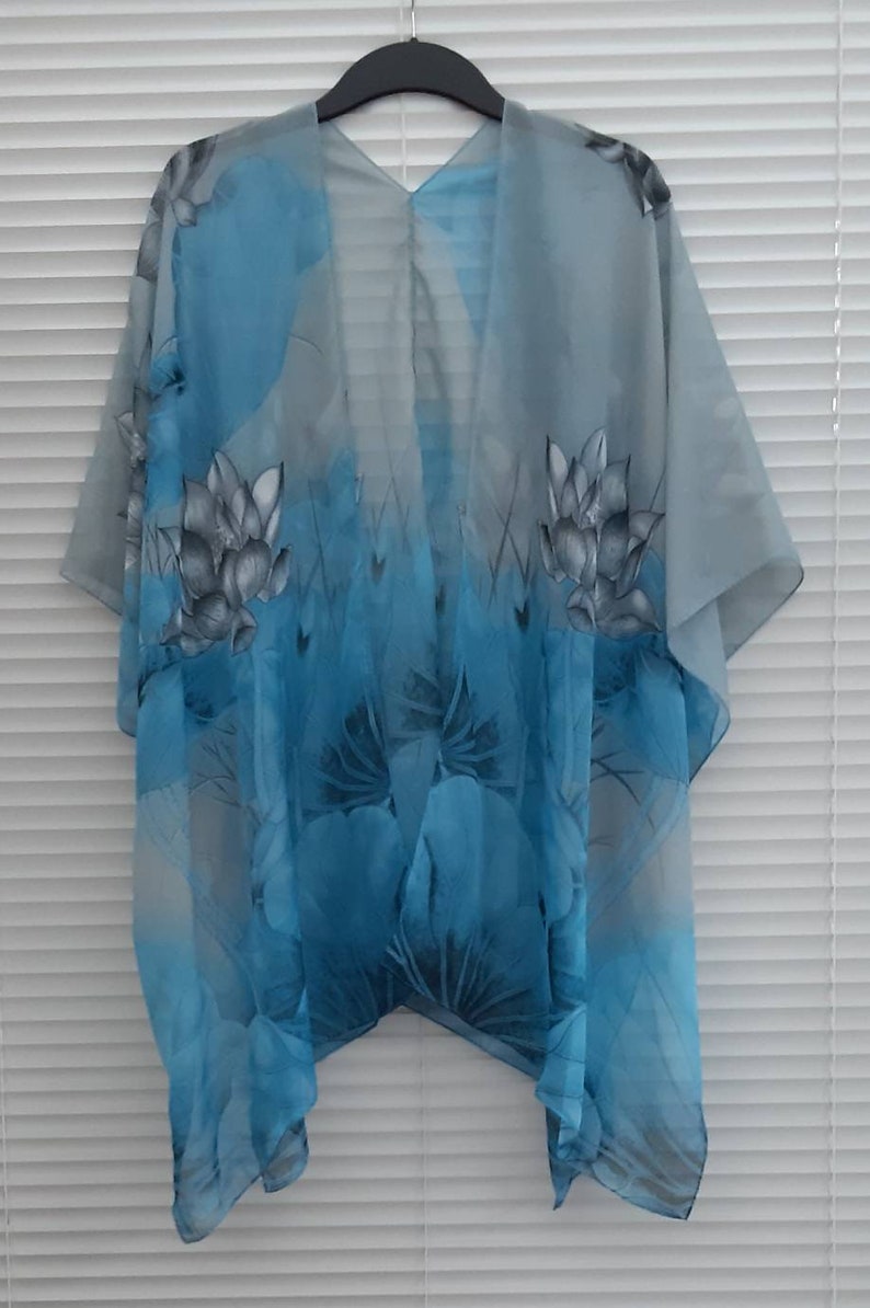 May include: A sheer blue and gray floral print kimono with a V-neck and short sleeves.