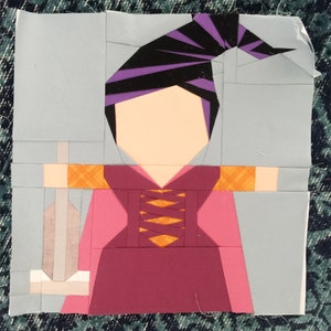 May include: A purple and black witch's hat with a pink and orange dress and a silver sword. The witch is holding the sword in her right hand.