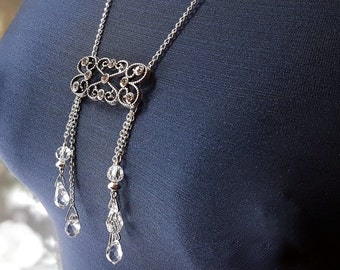 Stylish silver, crystal necklace with teardrop dangles and detailed centerpiece. Art Nouveau inspired