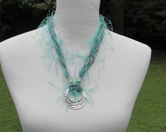 Collier de fils turquoise et de laine d’argent à la main orné d’un pendentif argenté et de deux perles