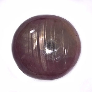 May include: A round, cabochon-cut, purple star sapphire gemstone with a six-rayed star.