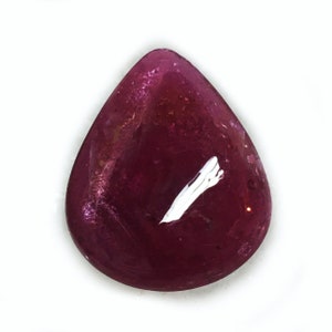 May include: A teardrop-shaped, deep pink gemstone with a white inclusion.