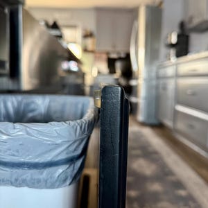 May include: A white ceramic mug with a black handle and the text "But First, Coffee" in a black, handwritten-style font. The mug is on a white surface.