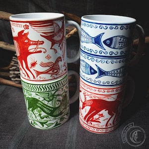 May include: Four ceramic mugs with different designs. The mugs are stacked in pairs. The top mug on the left has a red and white design with a mythical creature. The top mug on the right has a blue and white design with fish. The bottom mug on the left has a green and white design with a mythical creature. The bottom mug on the right has a red and white design with a deer.