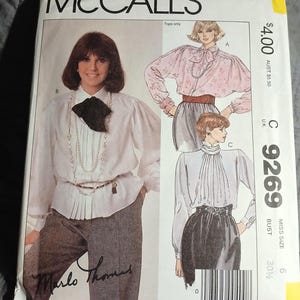 Puede incluir: Patrón de costura McCall's número 9269 para una blusa de mujer. El patrón incluye tres estilos diferentes de blusas con cuello alto y mangas largas. El patrón es para una talla 6, busto 30 1/4 pulgadas.