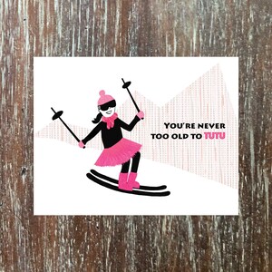 skiënde verjaardagskaart met hete roze tutu en girlpower, adventure vibe, 'Here's to another year of joy-filled adventure'
