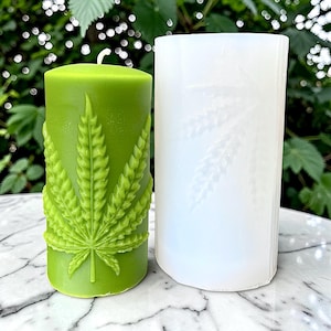 Pode incluir: Uma caneca de cerâmica branca com uma alça preta e o texto "But First, Coffee" em preto, com uma fonte manuscrita. A caneca está sobre uma superfície branca.