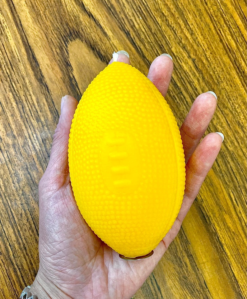 K&ouml;nnte beinhalten: Ein leuchtend gelber Gummifu&szlig;ball mit strukturierter Oberfl&auml;che.