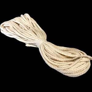 May include: A close-up of a white braided cotton rope. The rope is thick and has a soft texture.