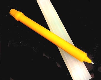 May include: A yellow candle with a white wick and a clear plastic case. The candle is about 10 inches long.