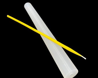 Puede incluir: Una herramienta blanca de forma cónica con un pequeño agujero en la base, junto con un fino aplicador amarillo. El aplicador está en ángulo sobre la herramienta blanca. Los elementos están sobre un fondo negro.