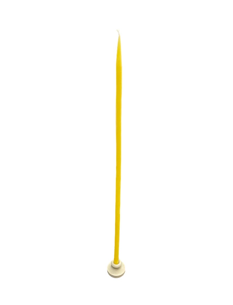 May include: A long, yellow beeswax candle with a white tip, standing on a small white base.