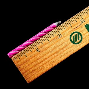 以下が含まれることがあります： ピンクと白のストライプの誕生日ろうそくで、長さは約5cmです。
