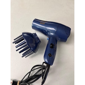 May include: A dark blue Sassoon 1600 hair dryer with a detachable finger diffuser attachment. The device features a handle with a black power cord, a side-mounted switch for heat and speed settings, and gold text on the barrel indicating the model.