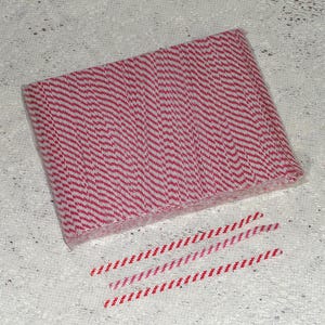 May include: A package of red and white striped paper straws. The straws are bundled together and wrapped in clear plastic.