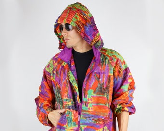 Può includere: Una giacca colorata con motivo astratto e cappuccio viola. La giacca ha una chiusura a zip ed è realizzata in un materiale leggero.