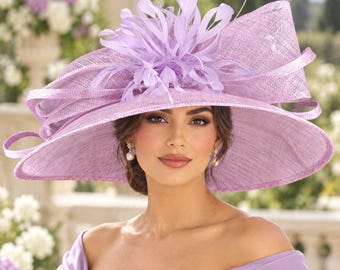 May include: A wide-brimmed lavender hat featuring a textured woven finish, a structured upturned side, and a decorative cluster of matching feathers at the center. The design includes looped ribbon accents that wrap around the crown.