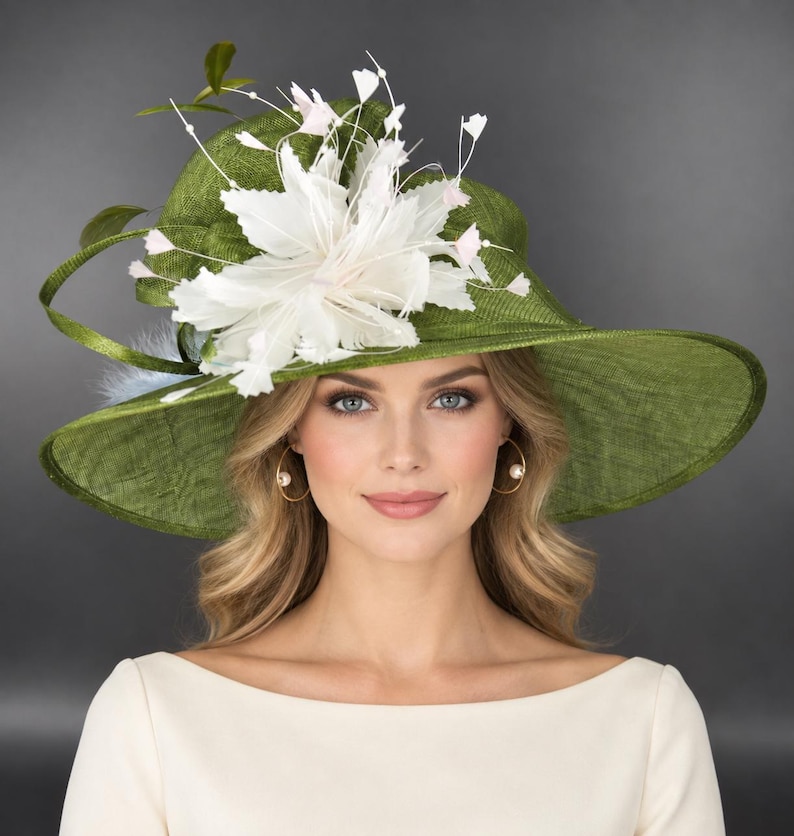 May include: A wide-brimmed olive green hat featuring a textured woven finish. The hat is adorned with a large, white, multi-layered floral embellishment made of delicate feathers and thin stems topped with small, pale pink accents.