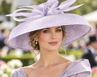 May include: A wide-brimmed lavender hat featuring a textured fabric finish and an elaborate decorative arrangement of stiffened, pointed loops and leaf-like structures centered on the crown. The hat has a structured, circular brim and a matching lavender dress.