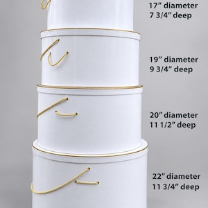 May include: A stack of four white round containers with gold trim and yellow rope handles. The sizes are: 17" diameter, 7 3/4" deep; 19" diameter, 9 3/4" deep; 20" diameter, 11 1/2" deep; and 22" diameter, 11 3/4" deep. Each container has a lid.
