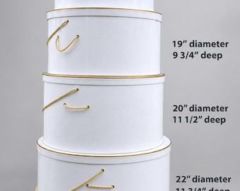 May include: A stack of four white round containers with gold trim and yellow rope handles. The sizes are: 17" diameter, 7 3/4" deep; 19" diameter, 9 3/4" deep; 20" diameter, 11 1/2" deep; and 22" diameter, 11 3/4" deep. Each container has a lid.