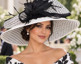 May include: A wide-brimmed hat featuring a white base with a black polka dot pattern on the crown and brim. The hat is adorned with a large black feather arrangement and a black mesh loop detail. The brim is structured with a black trim edge.