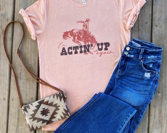 I’m Actin’ Up Again Rodeo Bucking Horse Bronco Cowboy Unisex Peach Triblend Tee T-Shirt Summer Concert