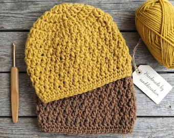 May include: Mustard yellow and brown crochet hat and cowl set. A ball of matching yarn and a crochet hook are next to the set. A tag reads "Handmade by canddcreation."