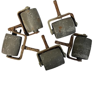 May include: Five vintage gray rollers with textured surfaces and rusty metal frames. Each roller has a cylindrical shape and is attached to a metal bracket with a handle. The rollers appear to be antique or salvaged items.