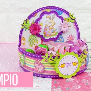 May include: A purple and green Easter basket with a bunny and eggs design. The basket is filled with chocolate eggs and has a "Love you" tag attached.