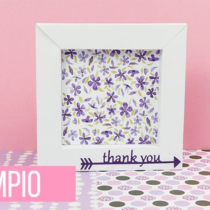 May include: A white picture frame with a floral pattern inside. The frame has a black arrow with the text "thank you" on the bottom.