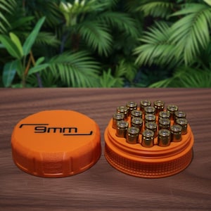 May include: An orange ammunition container with the text "9mm" on the lid, next to a tray of brass-cased bullets. The container is on a wooden surface with a green leafy background.