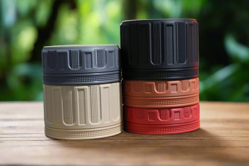 May include: A collection of cylindrical containers in various colors, including tan, black, red, and brown. Each container has a ribbed design on the lid and body. The containers are stacked and arranged on a wooden surface.