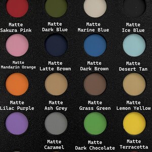 May include: A black palette featuring 18 matte eyeshadow shades in various colors, including red, pink, blue, orange, and green. Each color is labeled with its name, such as "Dark Red" and "Sakura Pink".