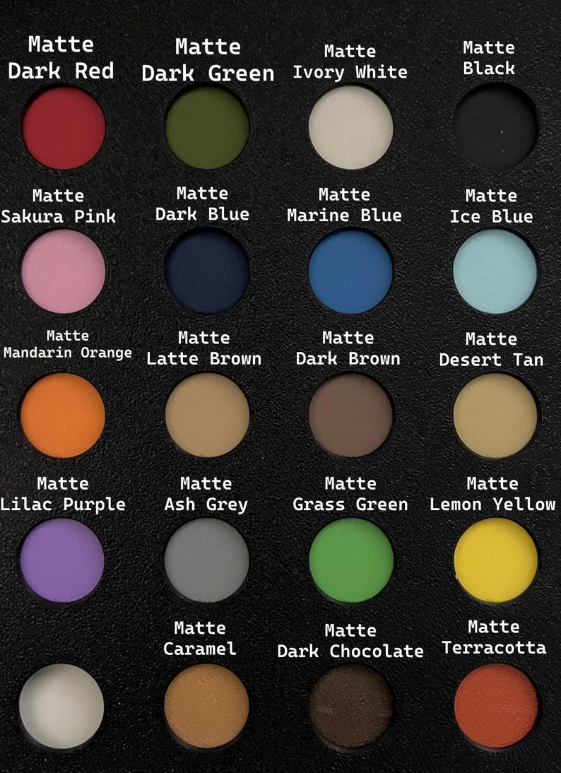 May include: A black palette featuring 18 matte eyeshadow shades in various colors, including red, pink, blue, orange, and green. Each color is labeled with its name, such as "Dark Red" and "Sakura Pink".