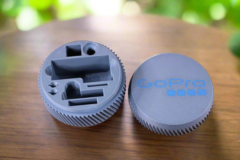 Pu&ograve; includere: Una scatola di contenimento in plastica grigia con scomparti per piccoli oggetti. La scatola ha un logo GoPro sul coperchio.