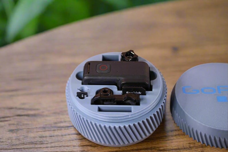 Pu&ograve; includere: Una custodia in plastica grigia con una fotocamera GoPro nera e accessori all'interno. La custodia ha una superficie testurizzata e scanalata e il logo GoPro &egrave; visibile sul coperchio.