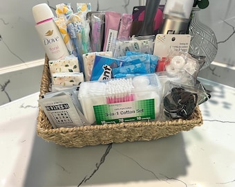 Puede incluir: Una cesta de junco marino tejida llena de varios artículos de cuidado personal, incluyendo un desodorante Dove floral fresh, un recipiente de plástico transparente 3 en 1 para algodón, toallitas quitamanchas, un kit de costura, un cepillo y artículos.