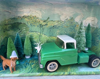 Feiertags-Weihnachtsdiorama mit Tonka-ähnlichem LKW, Hund, gegen die impressionistische grüne Wiese des Meistermalers