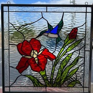 Stained glass window art of a mangrove tree in an ocean with purple and  pink flowers around the borders on Craiyon