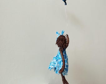 Niña con globo azul. Volador de globos. Escultura de Paverpol. Hecha a medida.
