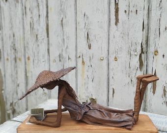 Escultura de una niña leyendo. Escultura de adoquín. Disponible.