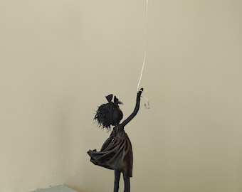 Escultura de niña con globo rojo en forma de corazón. Disponible.