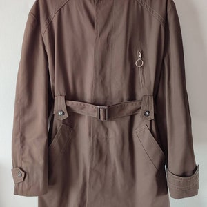 May include: A brown hooded jacket with a belt and a zipped pocket. The jacket has a soft, fluffy lining.