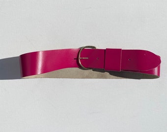 May include: A pink leather belt with a gold buckle.