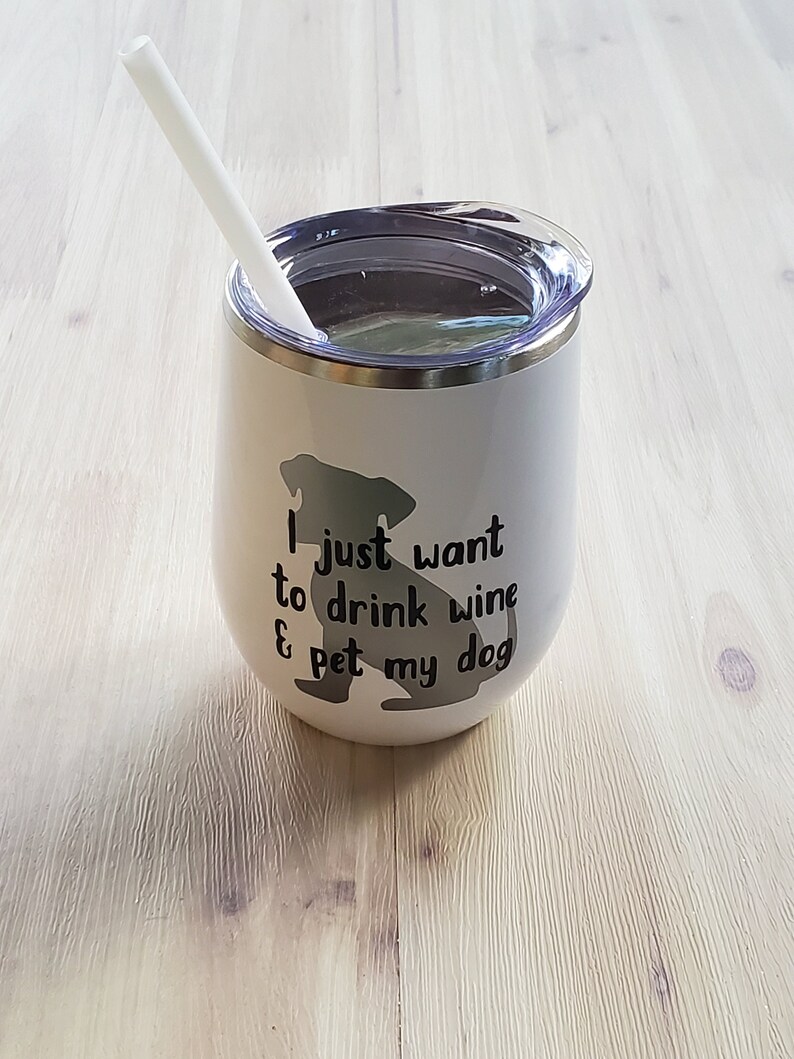 May include: White insulated wine tumbler with a clear lid and a white straw. The tumbler features a black silhouette of a dog and the text "I just want to drink wine & pet my dog."