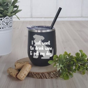 May include: Black insulated wine tumbler with a silver rim and a black straw. The tumbler has a white graphic of a dog and the text "I just want to drink wine & pet my dog."